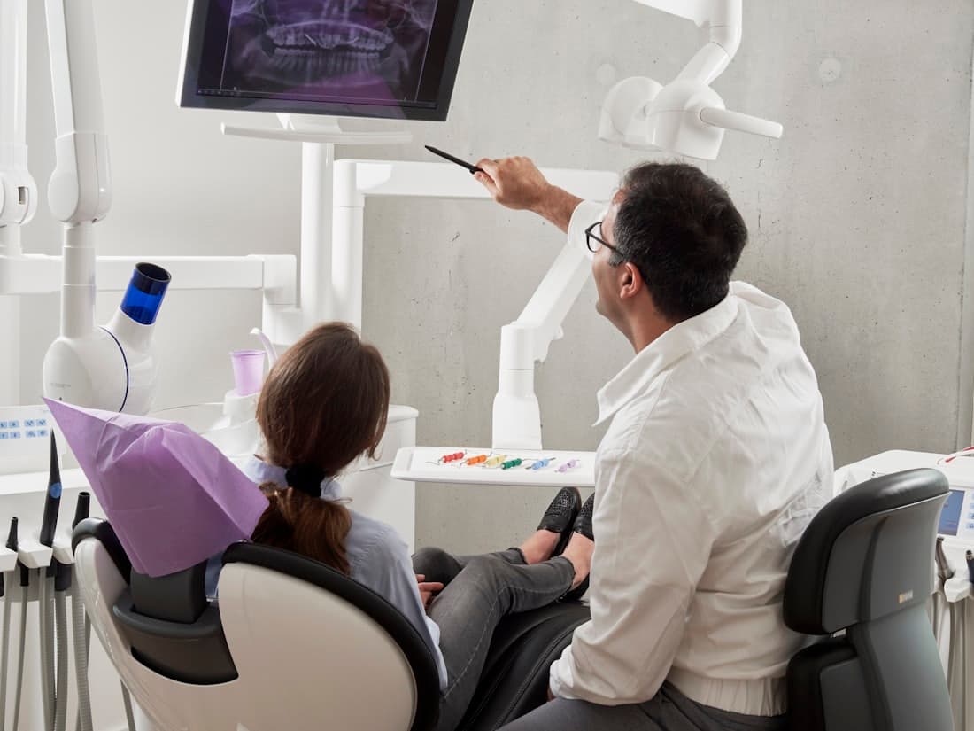 A dentist reviewing a patient's chart on screen in the operatory