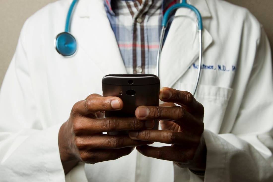 A physician with patient records on a mobile device